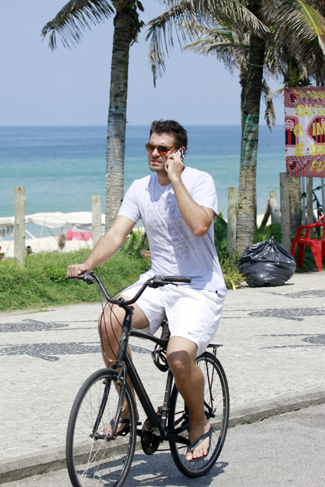 Thiago Lacerda anda de bike, corre na areia e nada no mar