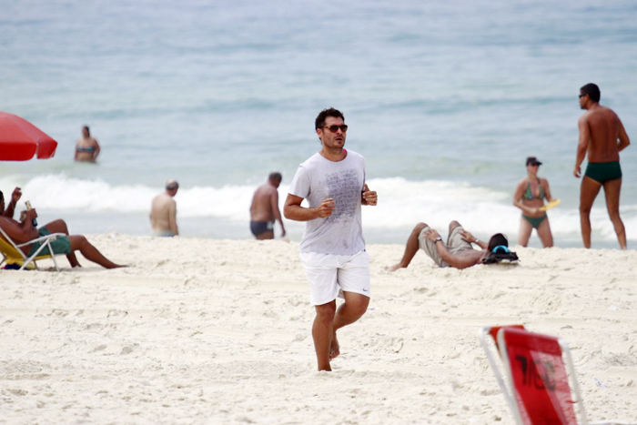 Thiago Lacerda anda de bike, corre na areia e nada no mar