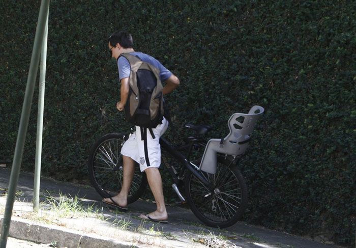 Um dia após ter a casa assaltada, Wagner Moura passeia de bicicleta com o filho