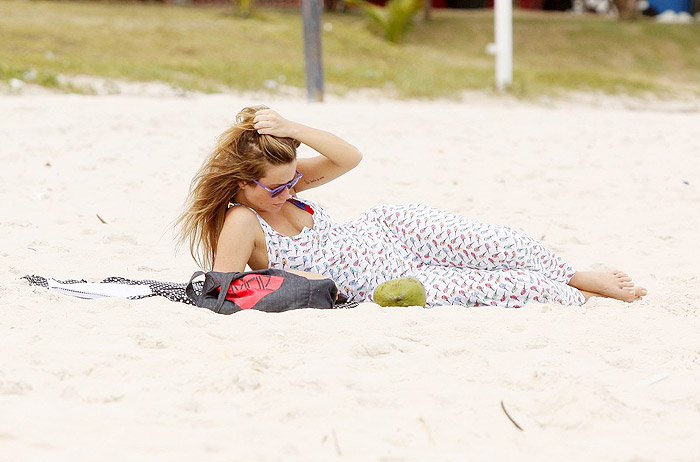 De vestido longo, Juliana Didone relaxa na praia da Barra da Tijuca