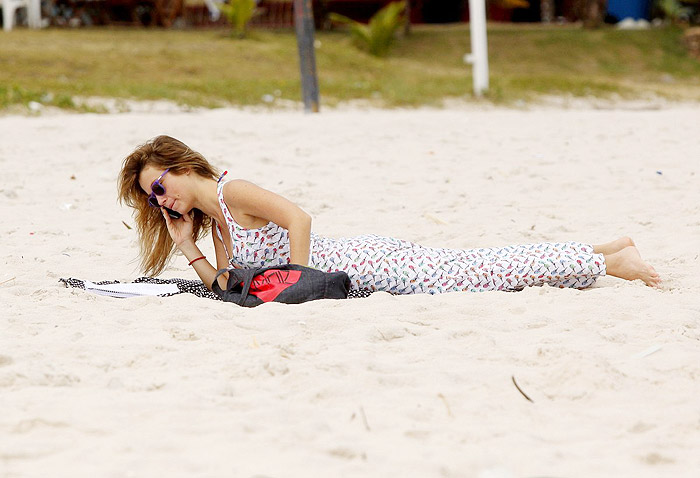 De vestido longo, Juliana Didone relaxa na praia da Barra da Tijuca