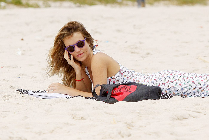 De vestido longo, Juliana Didone relaxa na praia da Barra da Tijuca