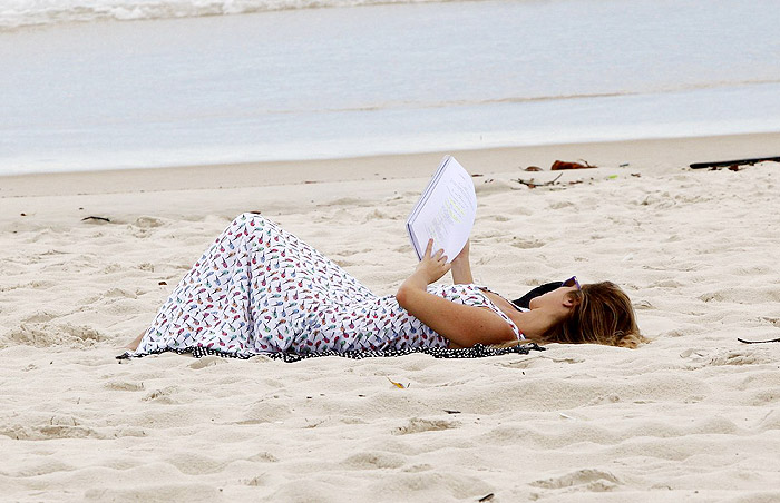 De vestido longo, Juliana Didone relaxa na praia da Barra da Tijuca