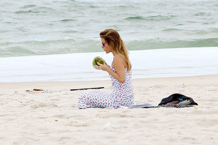 De vestido longo, Juliana Didone relaxa na praia da Barra da Tijuca