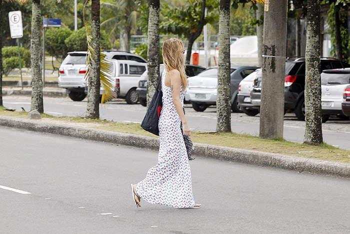 De vestido longo, Juliana Didone relaxa na praia da Barra da Tijuca