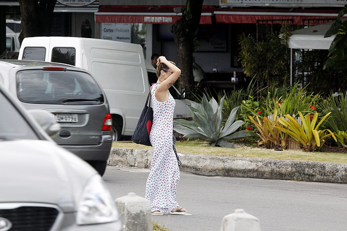 De vestido longo, Juliana Didone relaxa na praia da Barra da Tijuca