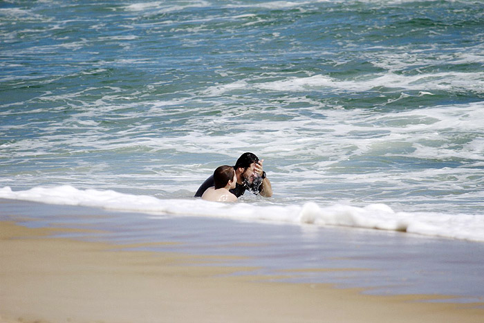 Murilo Benício brinca no mar com o filho