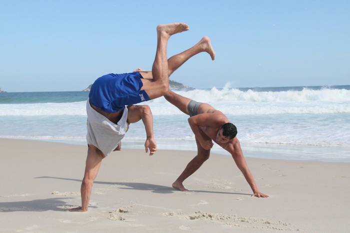 Kleber Bambam joga capoeira e fica de ponta-cabeça