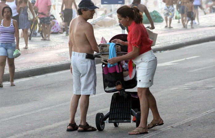 Totia Meirelles passeia com neto e marido pela orla do Leblon