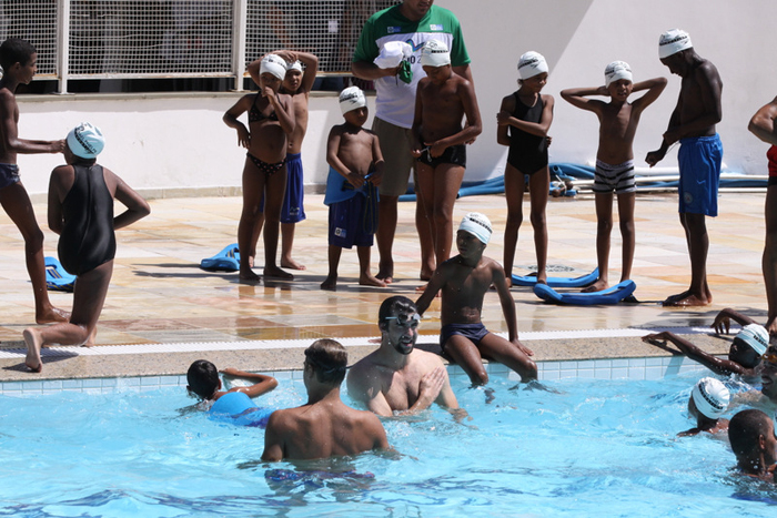 Michael Phelps interage com crianças no complexo esportivo da Rocinha, no Rio