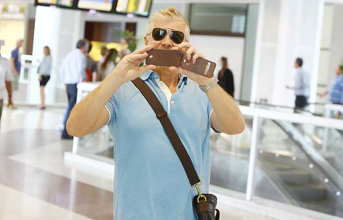 Miguel Falabella tira foto do paparazzo e compra chocolates no aeroporto