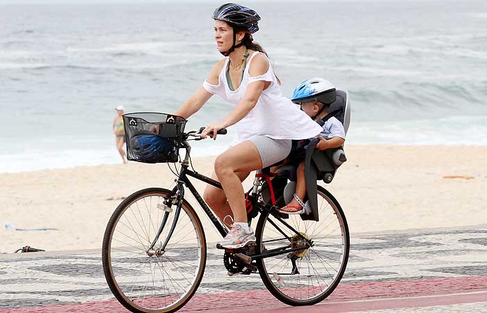 Claudia Abreu anda de bicicleta e leva seu filho de passageiro