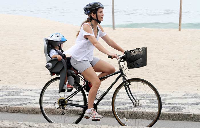 Claudia Abreu anda de bicicleta e leva seu filho de passageiro