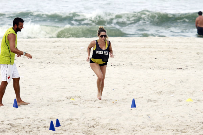 De micro short, Danielle Winits treina pesado na praia