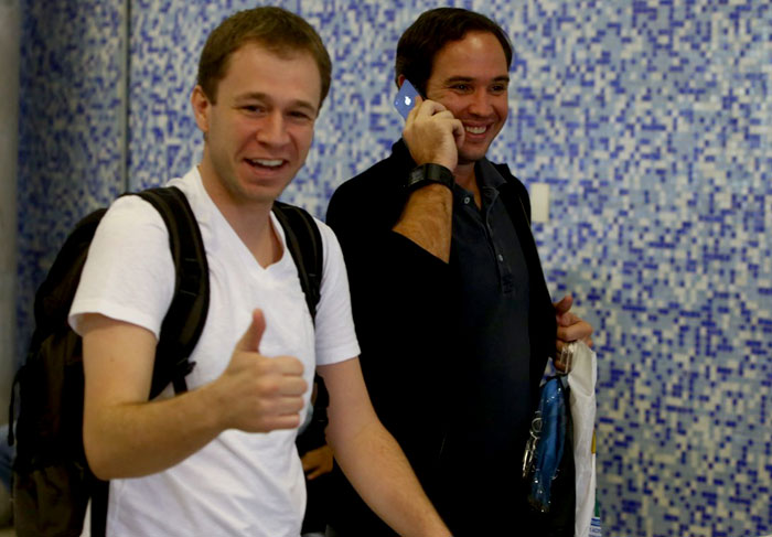 Danielle Winits e o namorado circulam de mãos dadas em aeroporto no Rio