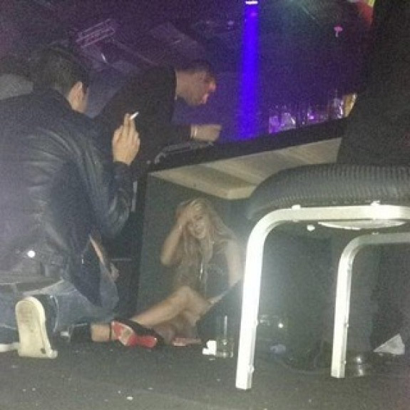 Lindsay Lohan se esconde debaixo da mesa em boate para se proteger dos paparazzi
