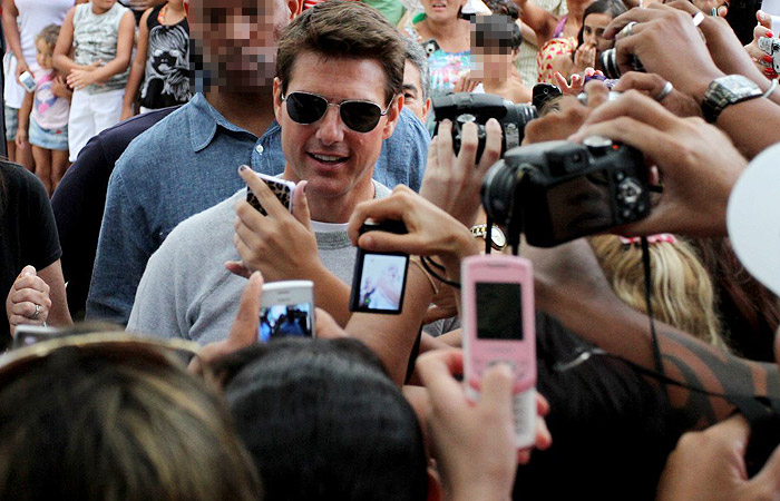 Tom Cruise conversa e tira fotos com fãs que lotaram a porta do hotel