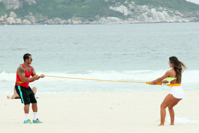 Com sainha branca, Nicole Bahls se exercita na praia