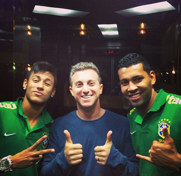 Em dia de futebol, Luciano Huck posa com Neymar e André Santos, no elevador O Fuxico