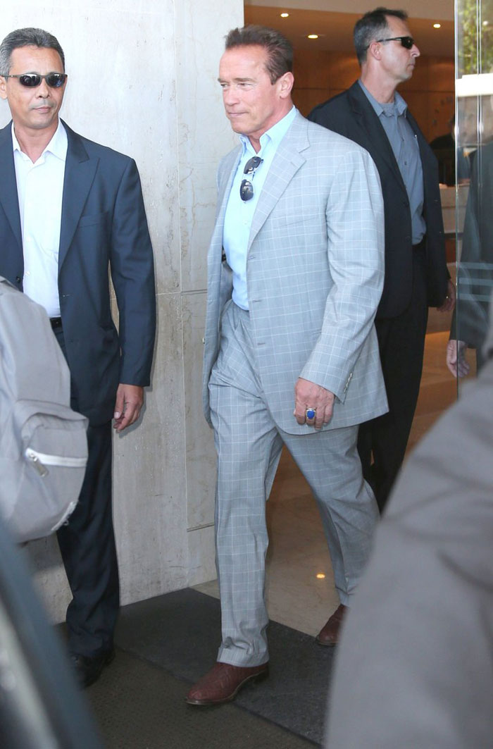 Sorridente, Arnold Shwarzenegger deixa hotel no Rio de Janeiro