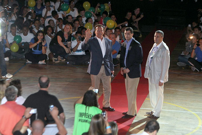 Arnold Schwarzenegger agita a garotada em vista à escola, no Rio