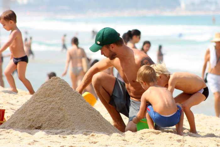 Rodrigo Hilbert faz castelo de areia com os filhos na praia