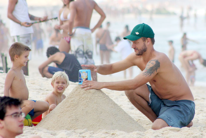 Rodrigo Hilbert faz castelo de areia com os filhos na praia