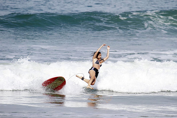 Dani Suzuki tem aulas de surf na praia da Macumba