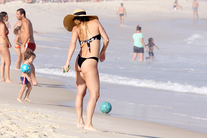 Danielle Winits exibe barriguinha saliente em praia do Rio
