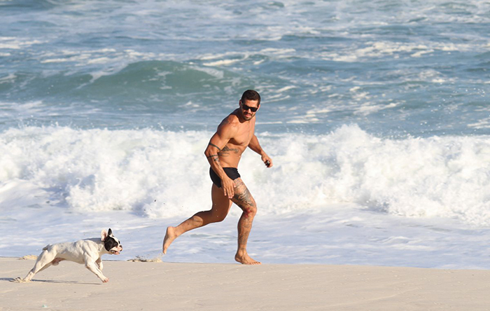 Ex-BBB Yuri Fernandes brinca com seu pet na praia