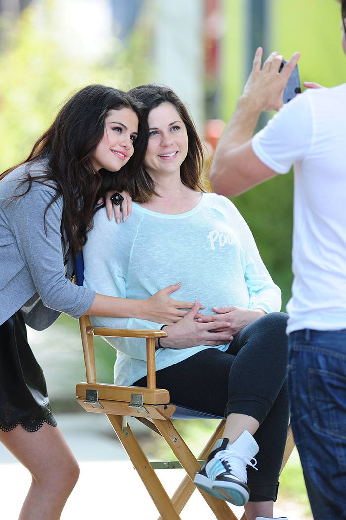 Selena Gomez posa acariciando a barriga da mãe, grávida 