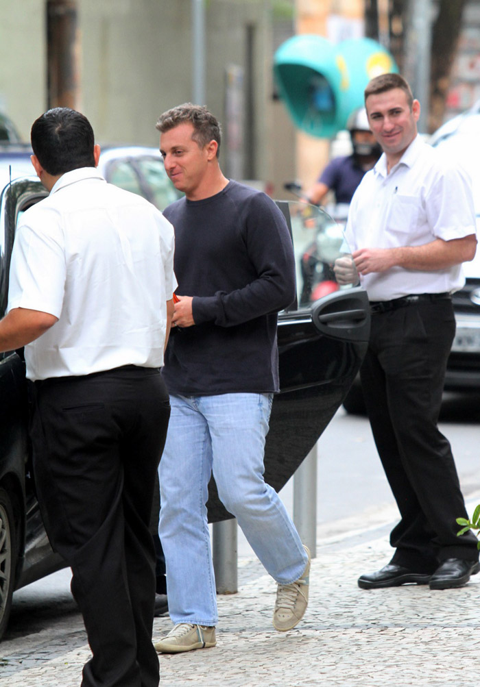 Luciano Huck acena para fotógrafos ao deixar restaurante, no Rio