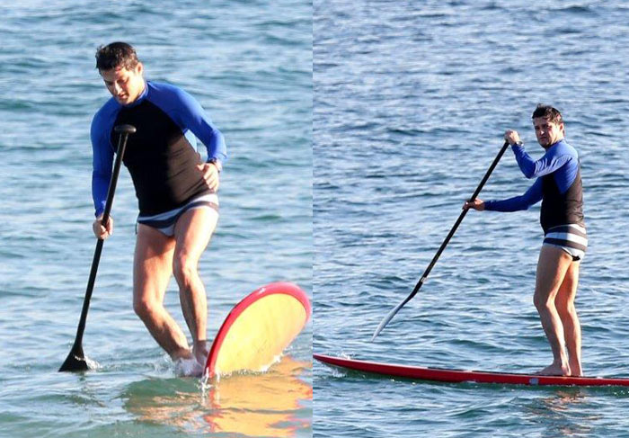 Enquanto os gêmeos curtem praia, papai Marcelo Serrado pratica stand up paddle 