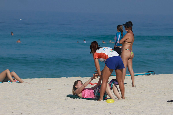 De roupa branca, Susana Werner dá um mergulho na praia da Barra 