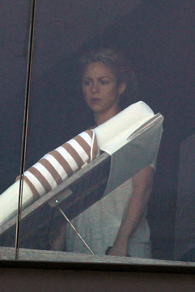Shakira olha atentamente pela janela do hotel, no Rio
