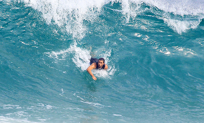 Cauã Reymond deixa a prancha de lado e nada na praia da Barra