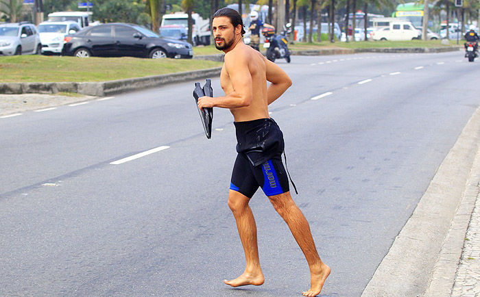 Cauã Reymond deixa a prancha de lado e nada na praia da Barra