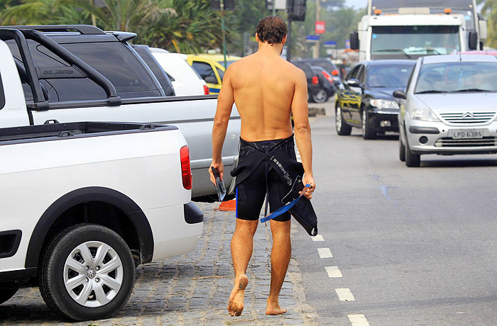 Cauã Reymond deixa a prancha de lado e nada na praia da Barra