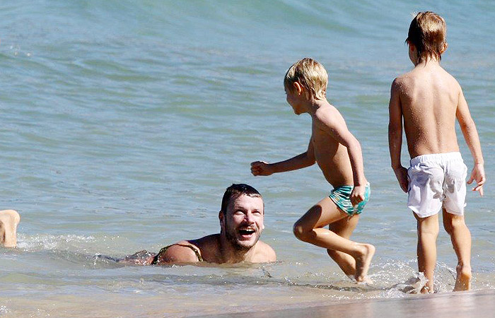 Rodrigo Hilbert vira prancha de surfe em farra com os filhos no mar
