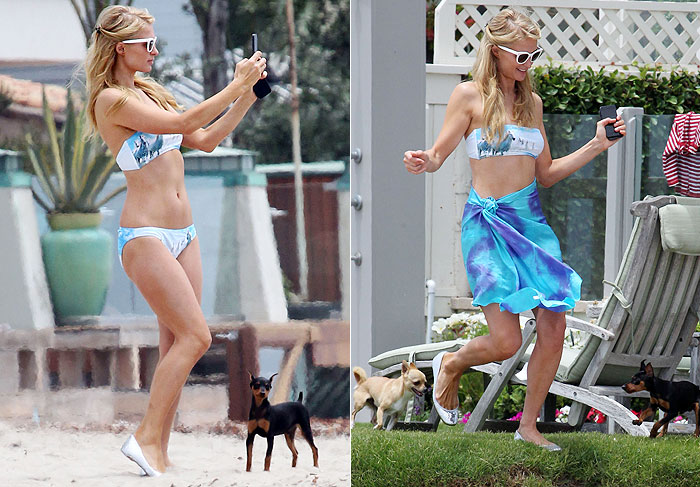 Paris Hilton curte praia de sapato com seus cachorros 