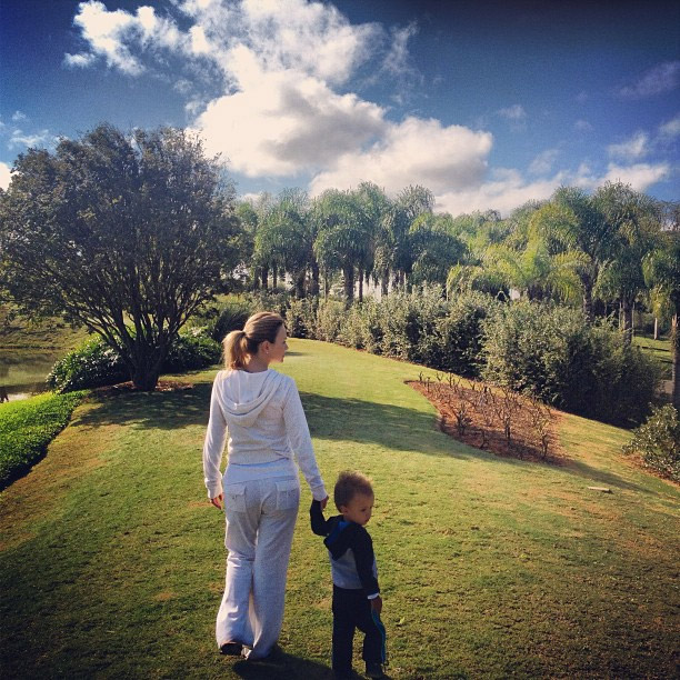 Eliana passeia com o filho em um belo jardim