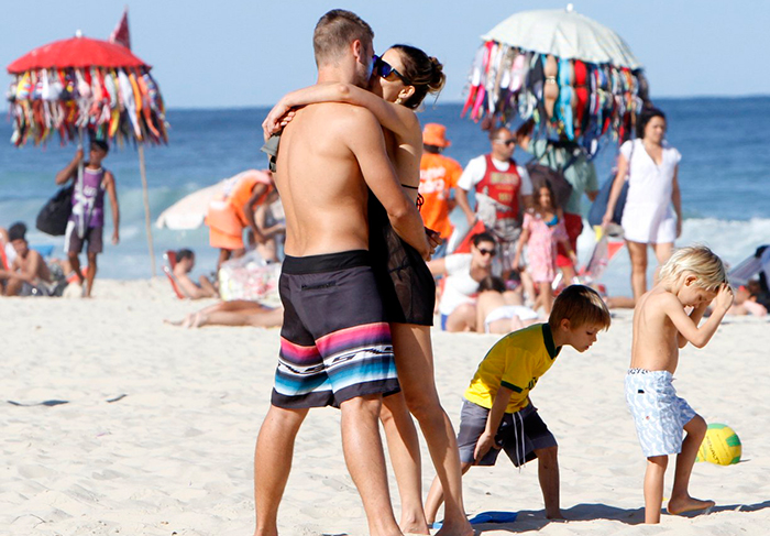 Fernanda Lima e Rodrigo Hilbert trocam beijos e carinhos na praia