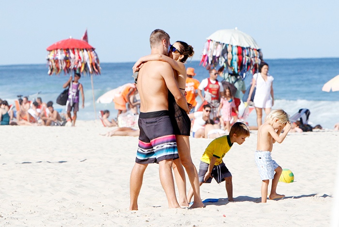 Fernanda Lima e Rodrigo Hilbert trocam beijos e carinhos na praia