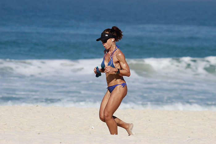 Carla Marins exibe o corpo sarado em corrida na praia