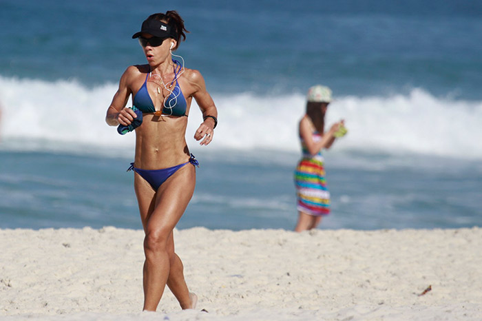 Carla Marins exibe o corpo sarado em corrida na praia