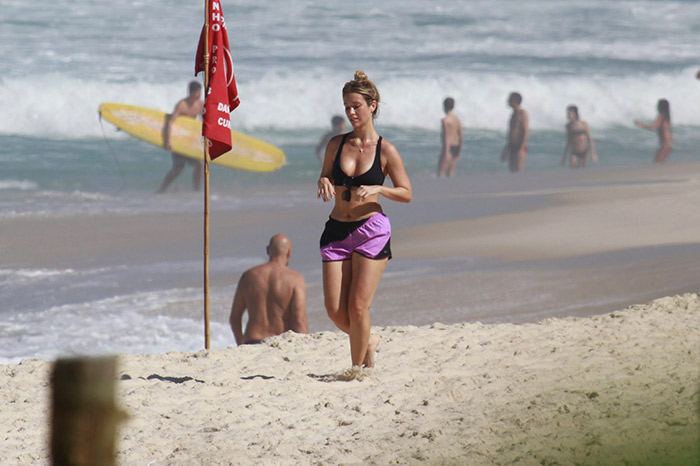  De shortinho e top, Juliana Didone se exercita em praia carioca