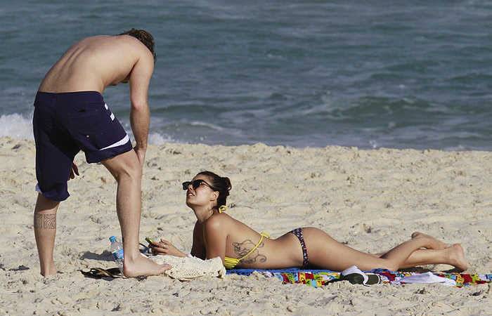 Ísis Valverde exibe sua tattoo e o belo corpo em tarde de sol na praia