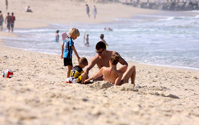 Fernanda Lima e Rodrigo Hilbert deitam na areia para brincar com filhos
