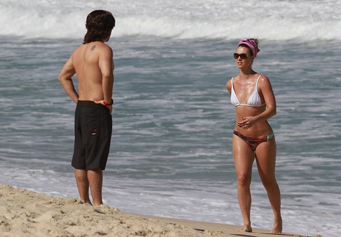 Camila Rodrigues exibe boa forma em dia na praia com o marido