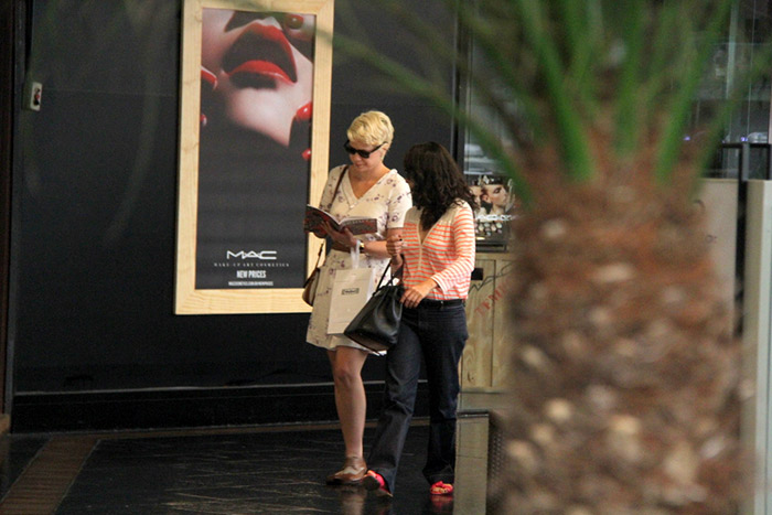 Leandra Leal lê revista durante passeio em shopping